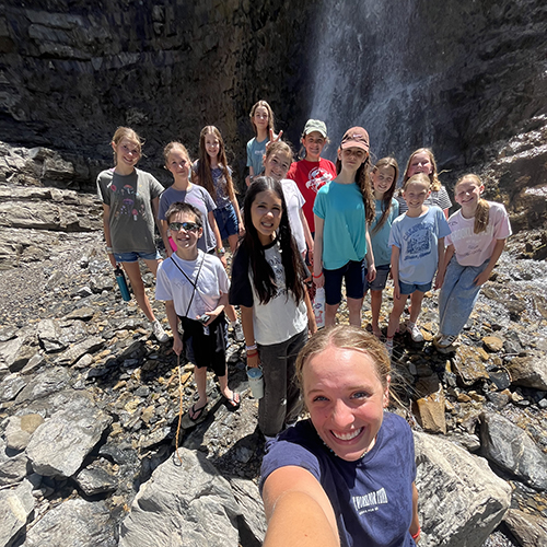 Group of youth hiking near a waterfall